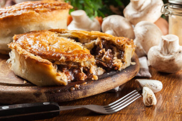 Fresh beef stew pie on a cutting board. Meat in puff pastry